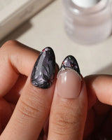 Belladonna press on nails with hand-painted dark lilies in silver outline on violet grey cat eye and nude nails edged in silver beads - image 4