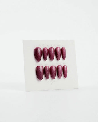 Ruby Red Cat-eye press-ons with glowing burgundy red color and glossy magnetic finish