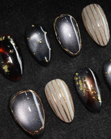 Black Lacquer press on nails with real gold foil in deep amber red and glossy black, gold studs and fine gold pinstripes on cream - image 1