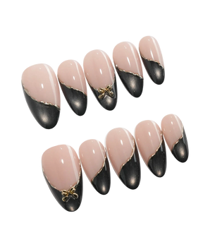 Black Tie press on nails with a black cat eye French tip edged in a fine gold line and a sculpted gold bow on a nude base - image 2