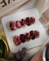 Bloody Kiss press-on nails in short square shape — deep red marble nude base 3D flower chrome beads sculpted gel drip design
