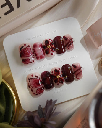 Bloody Kiss press-on nails in short square shape — deep red marble nude base 3D flower chrome beads sculpted gel drip design