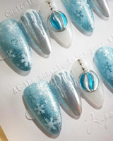 Frozen Dream nail art close-up showing ice blue ombre silver chrome snowflake charm details