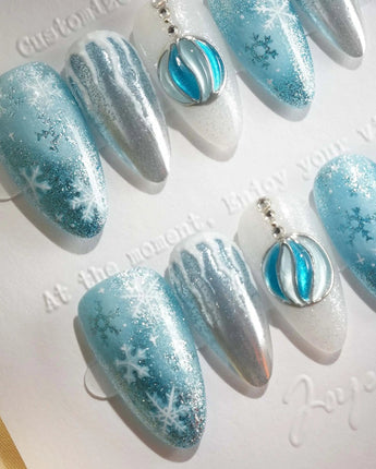 Frozen Dream nail art close-up showing ice blue ombre silver chrome snowflake charm details
