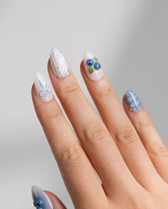 Blue Grid close-up of 3D blueberry charms on white and blue plaid nail art