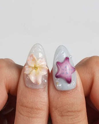 Blue Lagoon custom-size medium almond nails with shells, pearls and hibiscus blooms