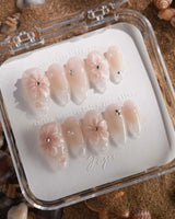 Blush Melt soft pink cat-eye nails with iced floral accents and glossy droplets