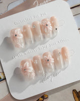 Blush Melt glossy summer press-on nails with pink cat-eye and clear petal accents