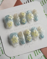 Bora Bora Blue medium oval nails with shimmering water texture and sculpted florals