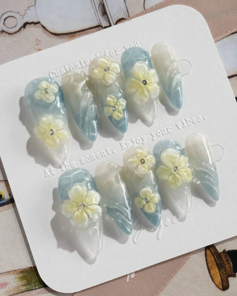 Bora Bora Blue medium stiletto nails with smoky blue water shimmer and 3D flowers