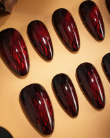 Burn nail art close-up showing Dark Red Cat Eye, Flowing Flame Texture. details