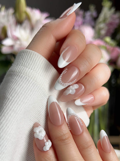 Nude French tip nails with sculpted camellia flowers