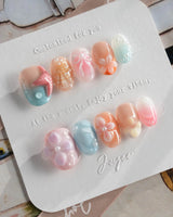 Candy Shore press-on nails with coral starfish, soft florals, and pastel beach shine