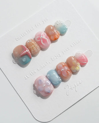 Candy Shore slow beach day nails with pastel shells, coral stars, and glossy florals