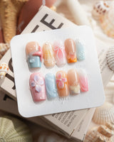 Candy Shore medium square nails with pastel sea elements, starfish, and florals