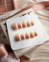 Caramel Chrome extra short squoval press-on nails with nude French tip styling with glossy gel finish