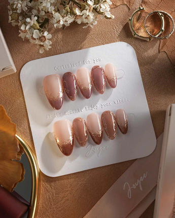 Caramel Petal press-on nails with rose chrome French tips, gold flourishes and soft nude base