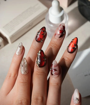 Carmine Court press on nails with sculpted gold leaves and silver pearls on deep red cat eye and a gold lattice on nude nails - image 2