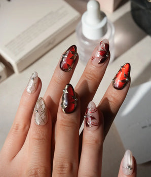 Carmine Court press on nails with sculpted gold leaves and silver pearls on deep red cat eye and a gold lattice on nude nails - image 2