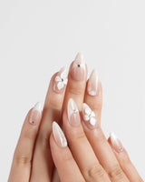 Ceramic handmade press-on nails featuring Classic Nude Pink Ombré, 3D White Florals & Minimalist Rhinestones.