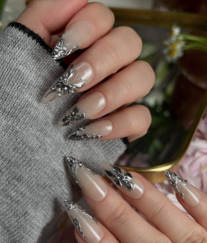 Chrome Rebellion handmade press-on nails featuring Nude, 3D Silver Butterflies & Liquid Metal.