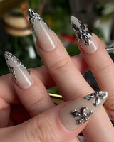 Chrome Rebellion nail art close-up showing Nude, 3D Silver Butterflies & Liquid Metal. details