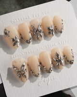 Chrome Rebellion press-on nails in extra short almond shape — Nude, 3D Silver Butterflies & Liquid Metal.