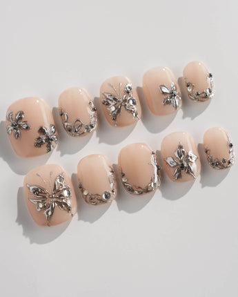 Chrome Rebellion press-on nails in extra short squoval shape — Nude, 3D Silver Butterflies & Liquid Metal.