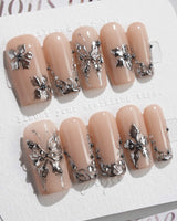 Chrome Rebellion press-on nails in medium square shape — Nude, 3D Silver Butterflies & Liquid Metal.