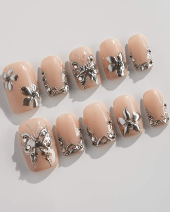 Chrome Rebellion press-on nails in short square shape — Nude, 3D Silver Butterflies & Liquid Metal.