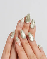Clover Field press-on nails in short almond shape — Fresh Grass Green, Hand-painted Metallic Florals & French Pearl Outlines.