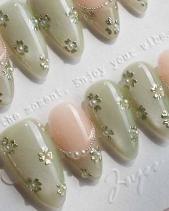 Clover Field press-on nails in short almond shape — Fresh Grass Green, Hand-painted Metallic Florals & French Pearl Outlines.