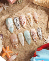 Coastline Edit spiral reef nail art with metallic seashell and pearl details