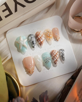 Coastline Edit ocean nails with brown-gold tide accents and sculpted shells