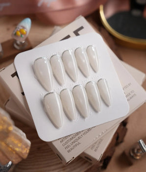Coco Water press-on nails in medium stiletto shape — Milky Jelly White, Minimalist Silver cat eye French Tips.