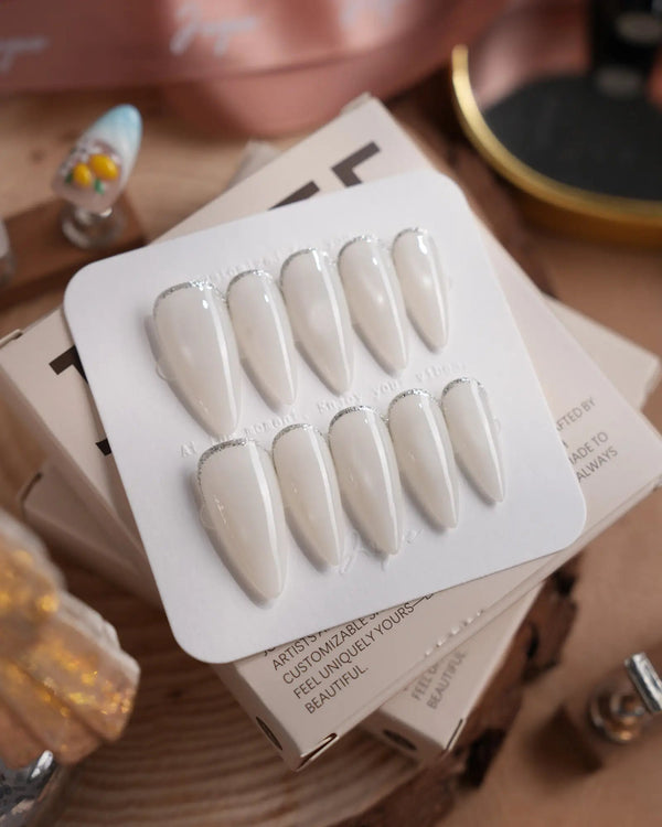 Coco Water press-on nails in medium stiletto shape — Milky Jelly White, Minimalist Silver cat eye French Tips.