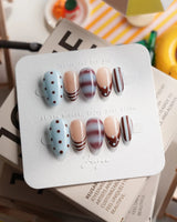 Cocoa Dot extra short almond press-on nails with brown, blue and nude skittle design