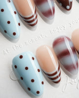 Cocoa Dot short almond nails with polka dots, stripes and deep wine marble swirls