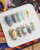 Como Blue ethereal press-on nails with pastel cat-eye ripples and 3D butterfly accents