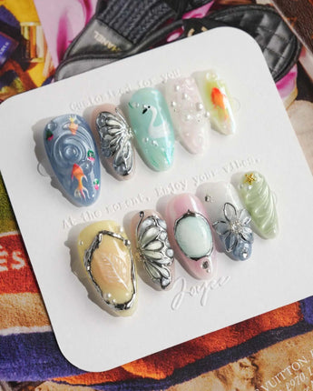 Como Blue ethereal press-on nails with pastel cat-eye ripples and 3D butterfly accents