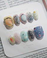 Como Blue hand-layered nail art with koi fish, feathers, and translucent water ripples