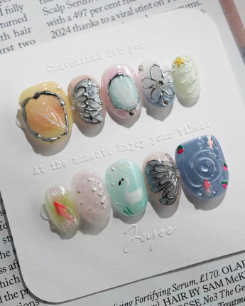 Como Blue hand-layered nail art with koi fish, feathers, and translucent water ripples