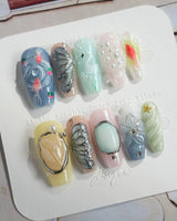 Como Blue medium coffin nails with pearly pastels, goldfish, and sculpted butterfly art