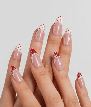 Coquette Dot blush nude nails with deep red dotted tips, gel bows and lace trim