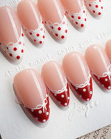 Coquette Dot medium almond press-on nails with red polka dot French tips and white lace