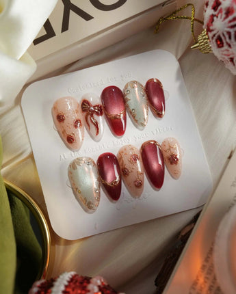 Coquette Red press-on nails with red chrome, nude accents, gold outlines and bow details