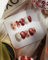 Coquette Red press-on nails with nude base, red chrome accents and gold bow nail art