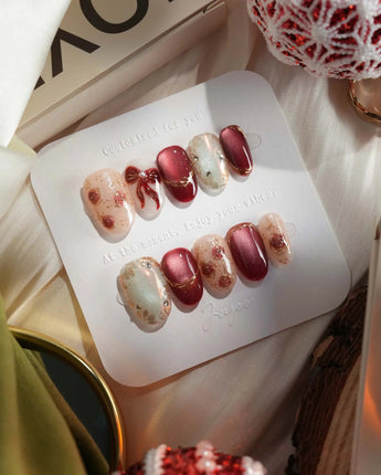 Coquette Red press-on nails with nude base, red chrome accents and gold bow nail art