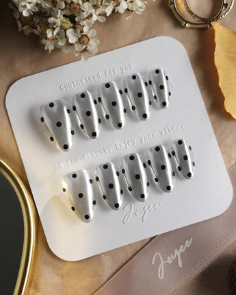 Cosmo Dots nail close-up with mirror silver base and bold black retro polka dots