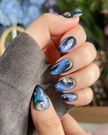 Cosmoseek extra short almond nails with cosmic blue shimmer and planet accents